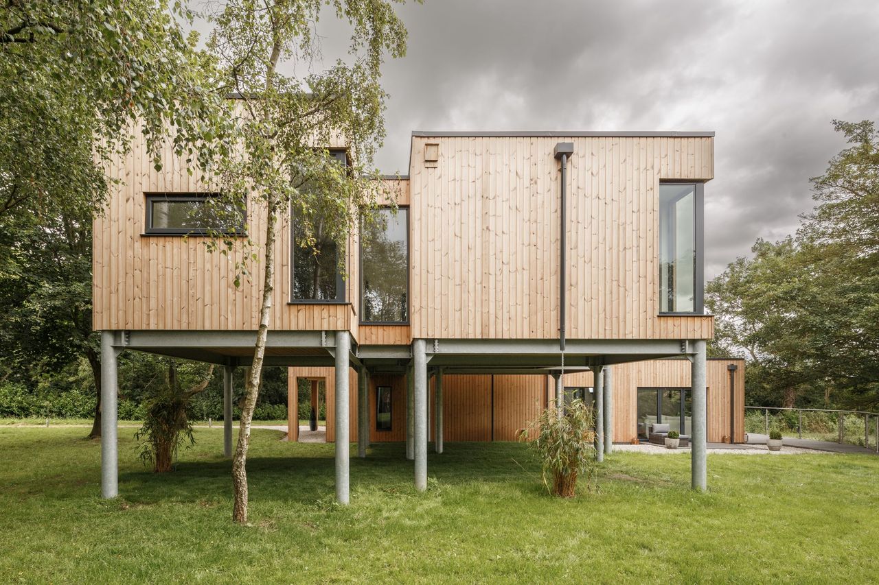 Floating upstairs pods supported by steel beams on a sloped site