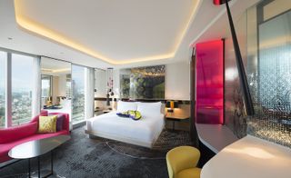 W Hotel bedroom with bed, sofa and floor to ceiling window