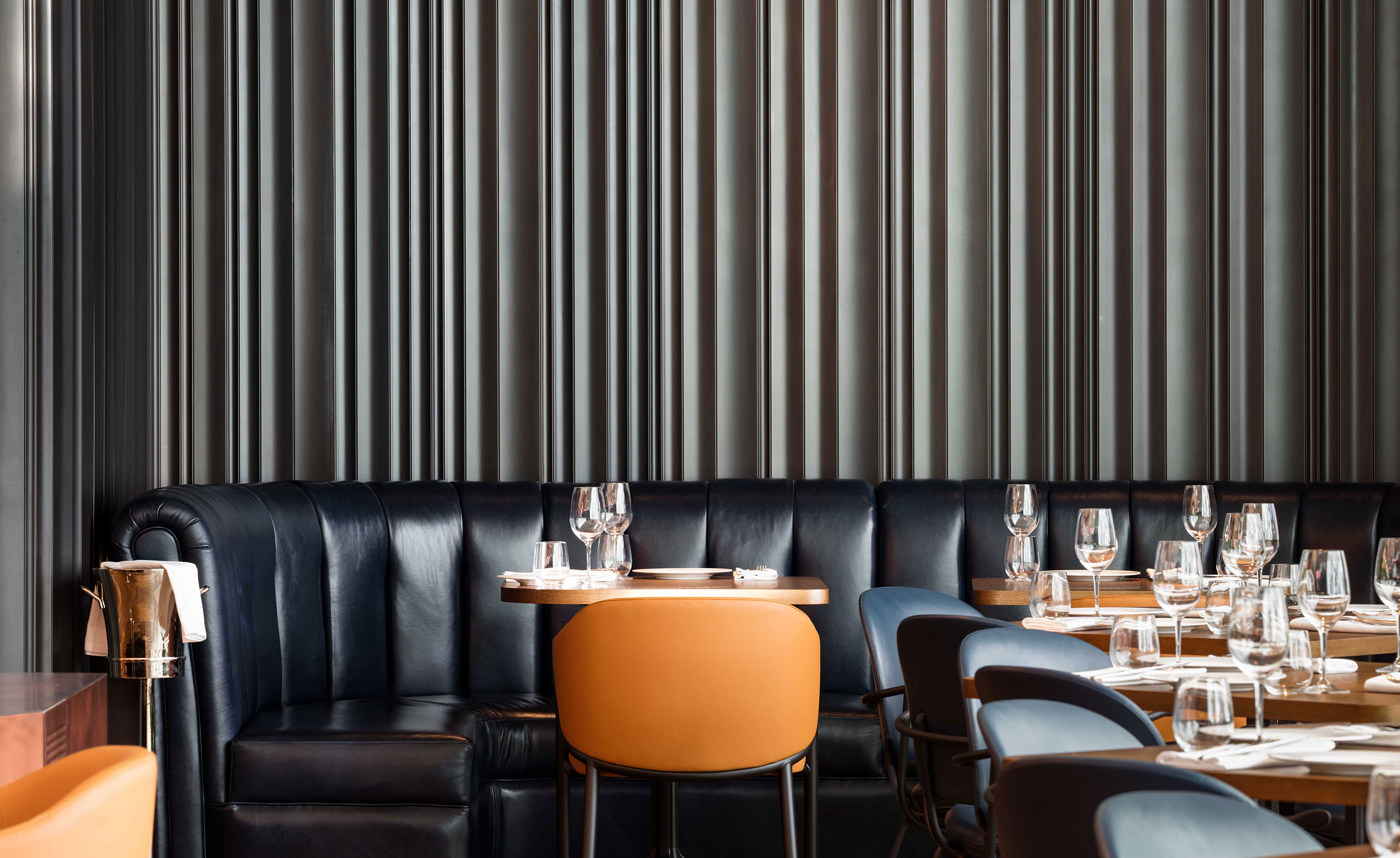 Long booth dining table with black & orange leather seats
