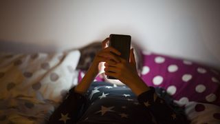 Child on smartphone in bed
