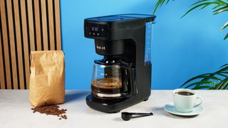 A black Instant Infusion Brew 12-Cup drip coffee maker with a removable water reservoir, glass carafe and reusable coffee filter