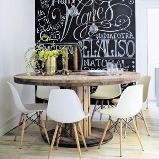 room with dining table chair wooden flooring and painted blackboard