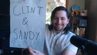 ConcernedApe holding a piece of paper that says "Clint & Sandy" to reveal the new marriage candidates in a Stardew Valley anniversary stream
