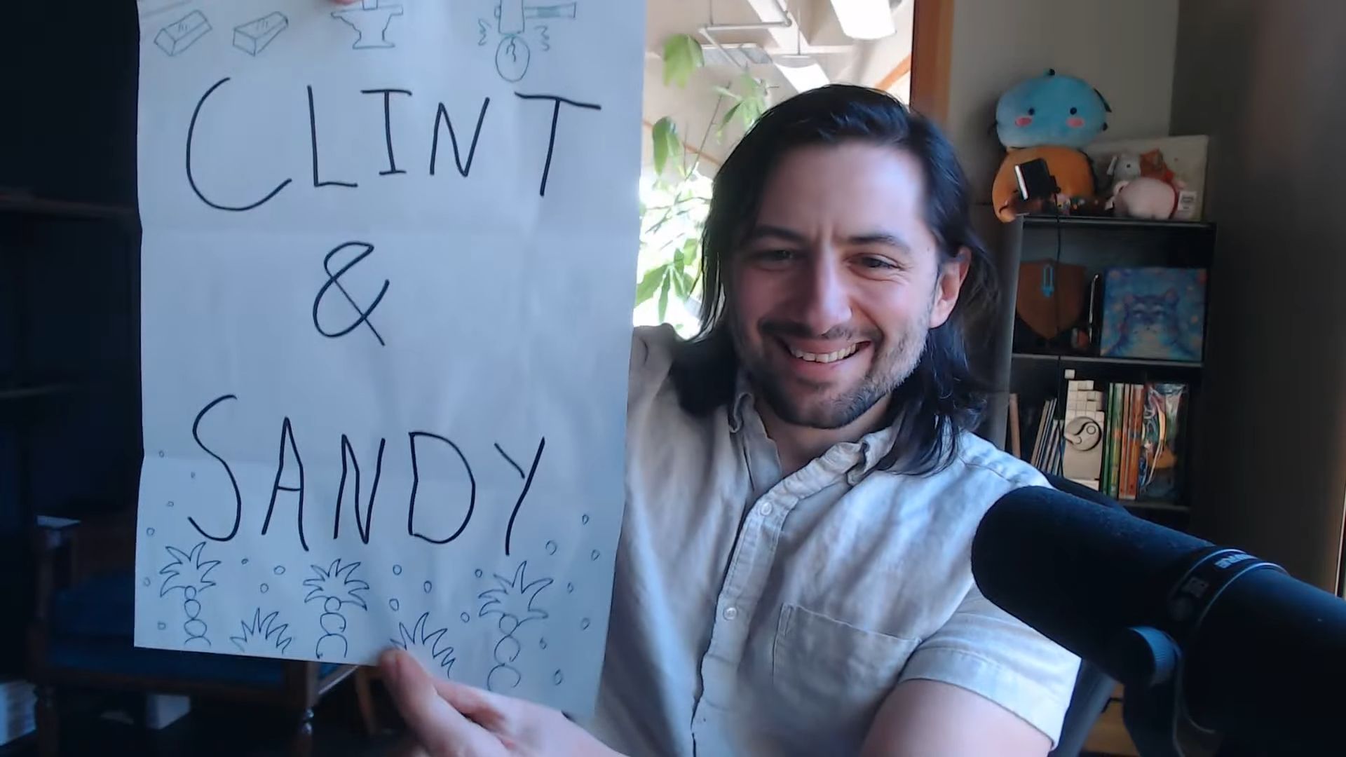ConcernedApe holding a piece of paper that says "Clint &amp; Sandy" to reveal the new marriage candidates in a Stardew Valley anniversary stream