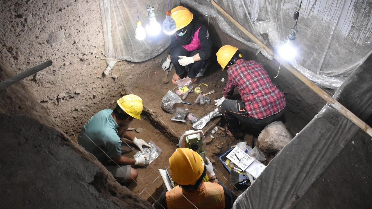 Researchers excavate the 7,200-year-old burial at Leang Panninge cave.