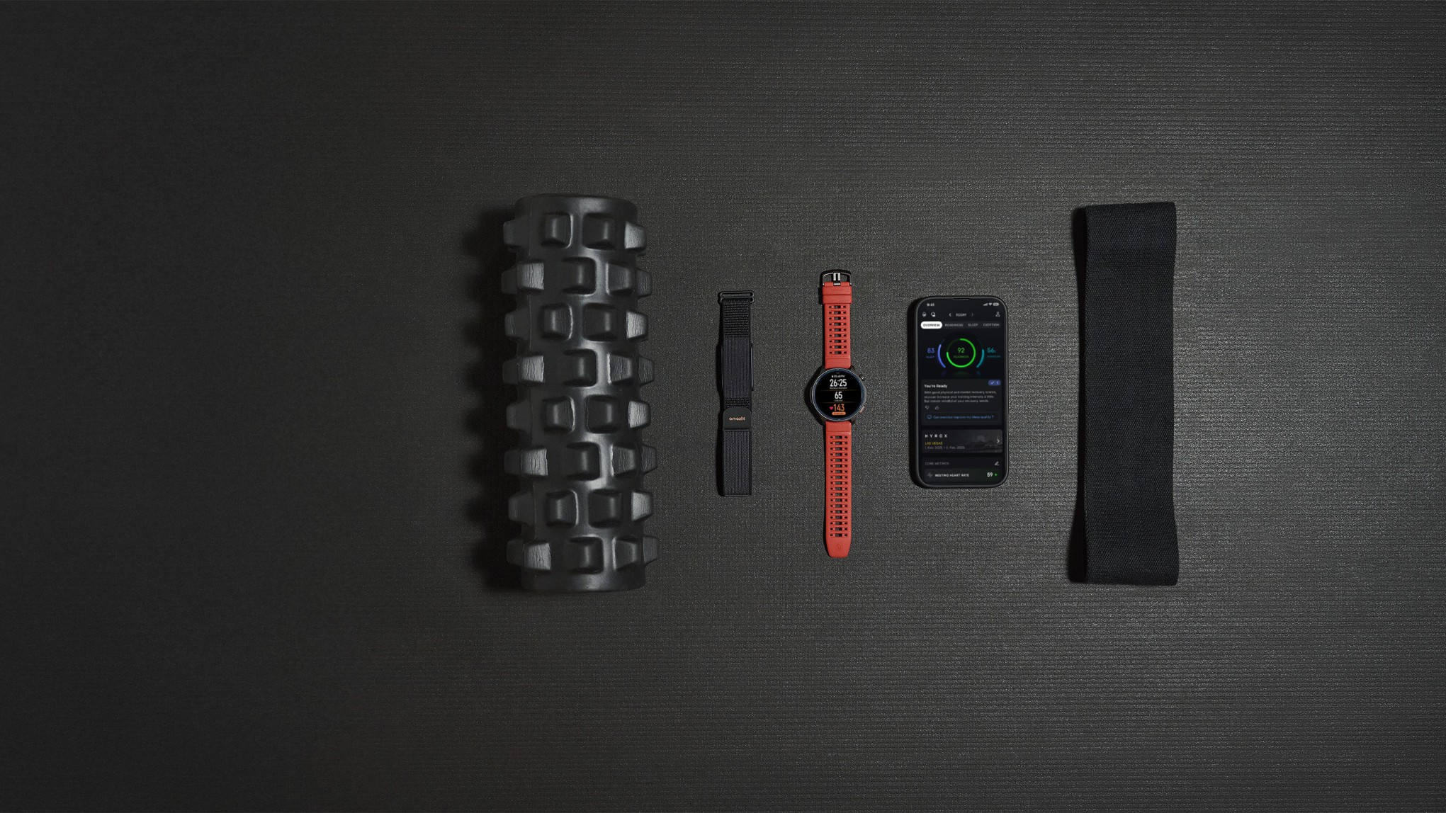 The Amazfit Balance 2 and Helio Strap devices beside a smartphone on a gym mat.