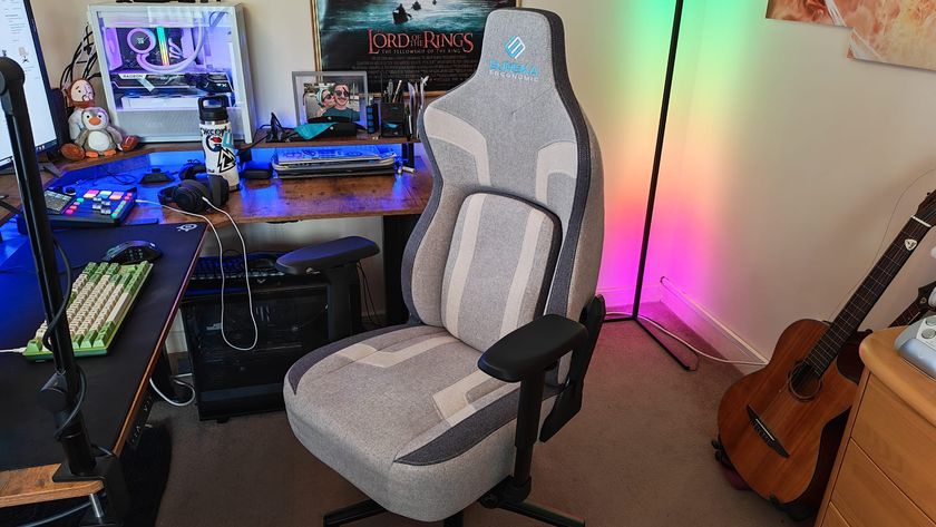 A Eureka Ergonomic Python II review image showing the chair at a gaming desk in front of some RGB lighting