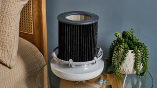 Picture shows the Molekule Air Mini Plus air purifier with its top removed, revealing the PECO-HEPA Tri-Power filter sitting within the base.