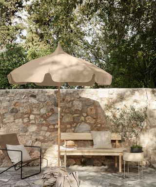 cobbled wall with table, chairs and umbrella
