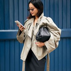 woman in trench coat looking at phone