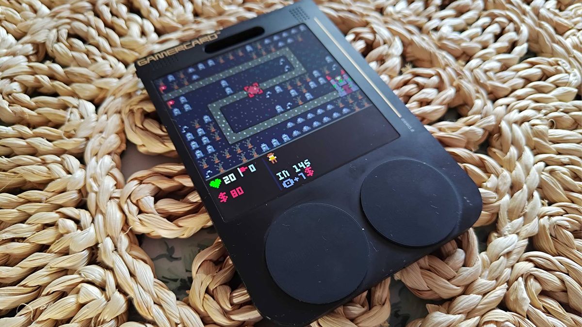 Gamercard on wicker table cover with PICO-8 Necromancer TD game on screen.