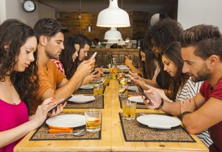 Phone addicted users at dinner table