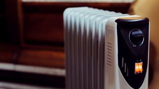 Oil filled radiator in room with dark wood background