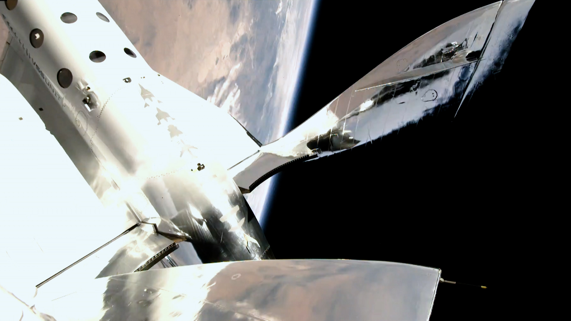 A view of the Earth and the feathered tail of Virgin Galactic's SpaceShipTwo VSS Unity during the Unity 22 flight on July 11, 2021.