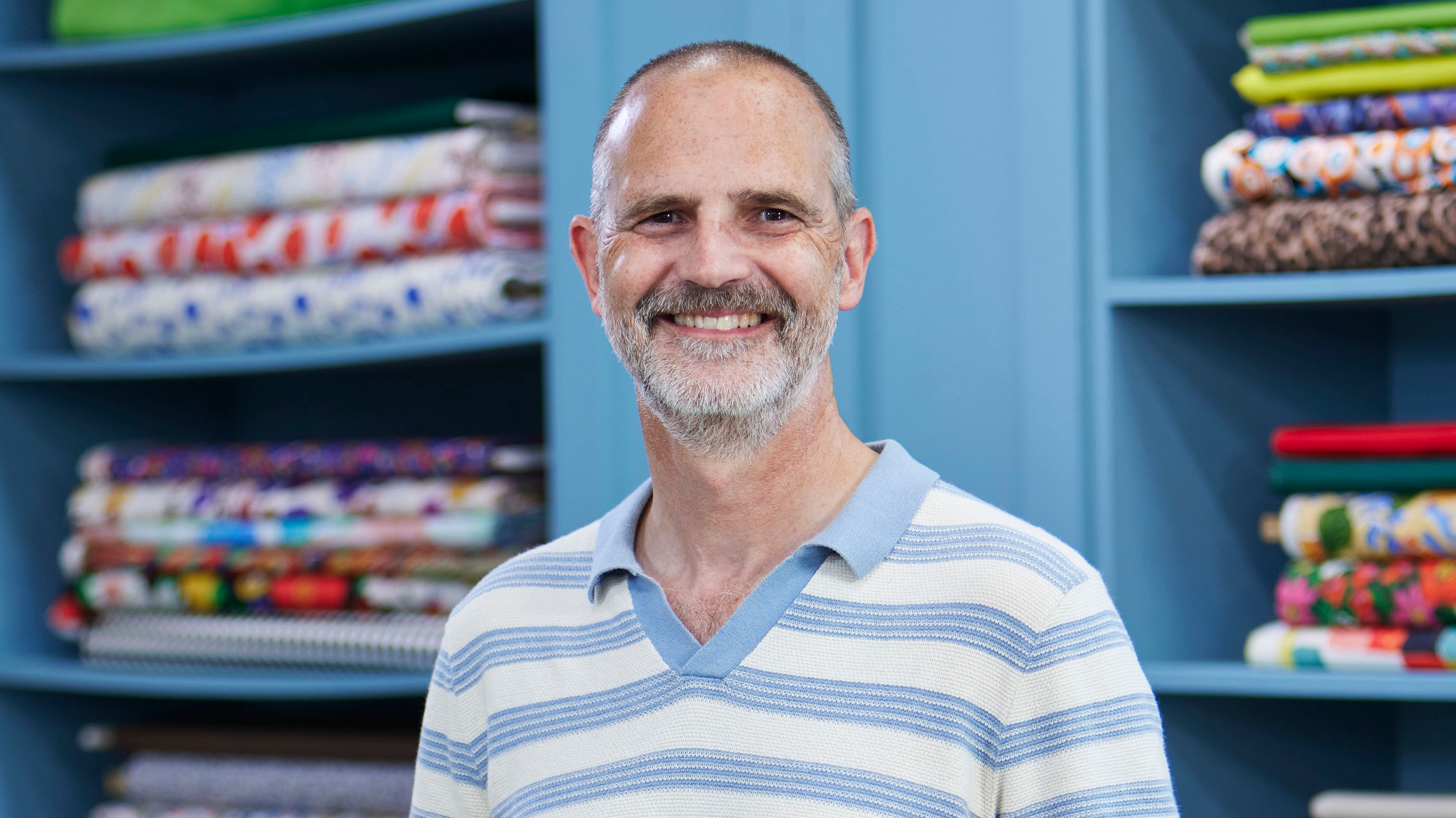 Stuart standing in the Great British Sewing Bee studio and smiling for the camera