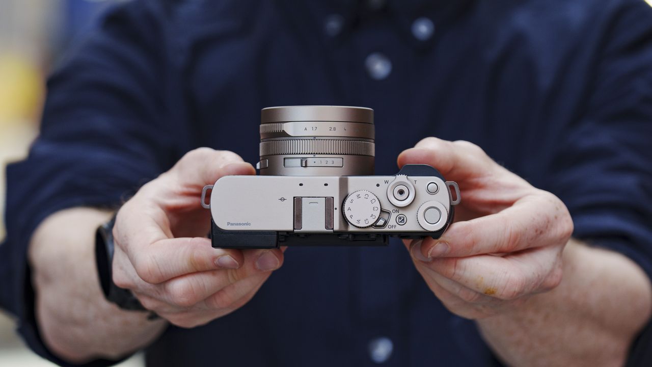 Man holding the Panasonic Lumix L10 compact camera in an urban setting of Japan