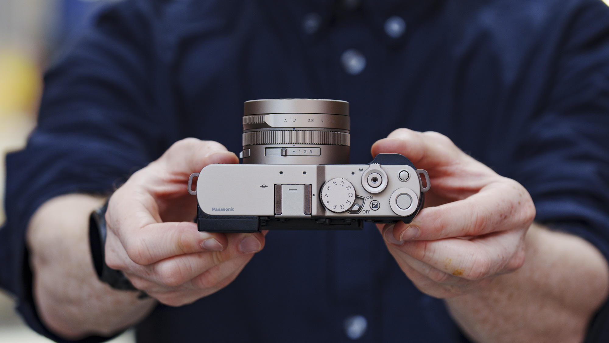 Man holding the Panasonic Lumix L10 compact camera in an urban setting of Japan
