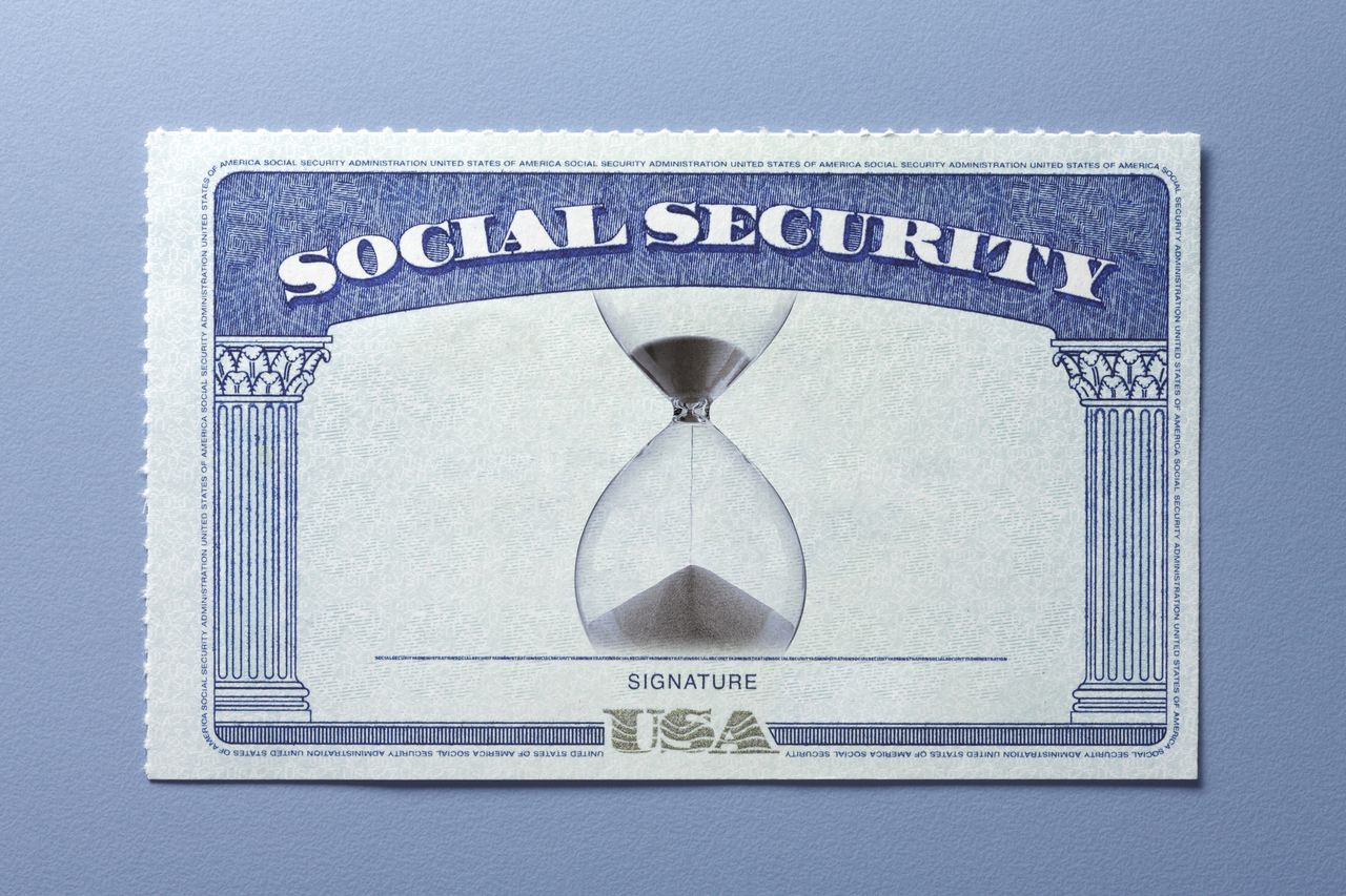 An hourglass on a social security card on a blue background.