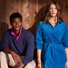 Two models one wearing a blue shirt dress and the other wearing a navy knit jumper and pink shirt sold ar Crew Clothing