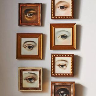 Square gold picture frames with paintings of eyes