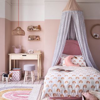bedroom with pink walls and wooden study table