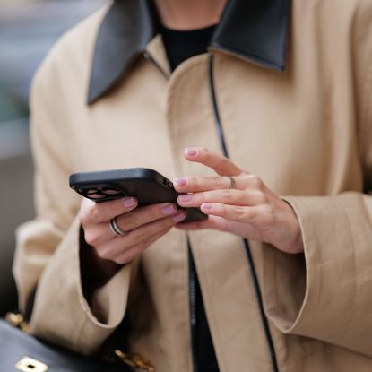 Woman with bb cream nails on her phone