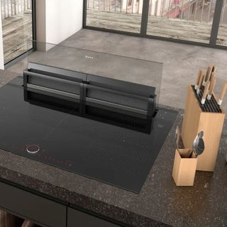 NEFF N90 I98WMM1S7B 92 cm Downdraft Cooker Hood at back of black hob on black kitchen island