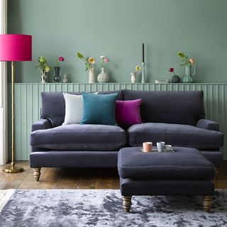 green wall living room with grey sofa