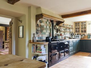 kitchen with colourful tiles, dark aga and blue cabinetry