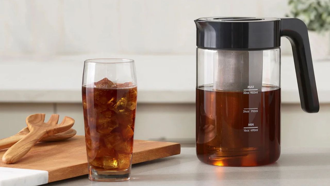 Instant cold brewer on the countertop next to a cup of cold brew 