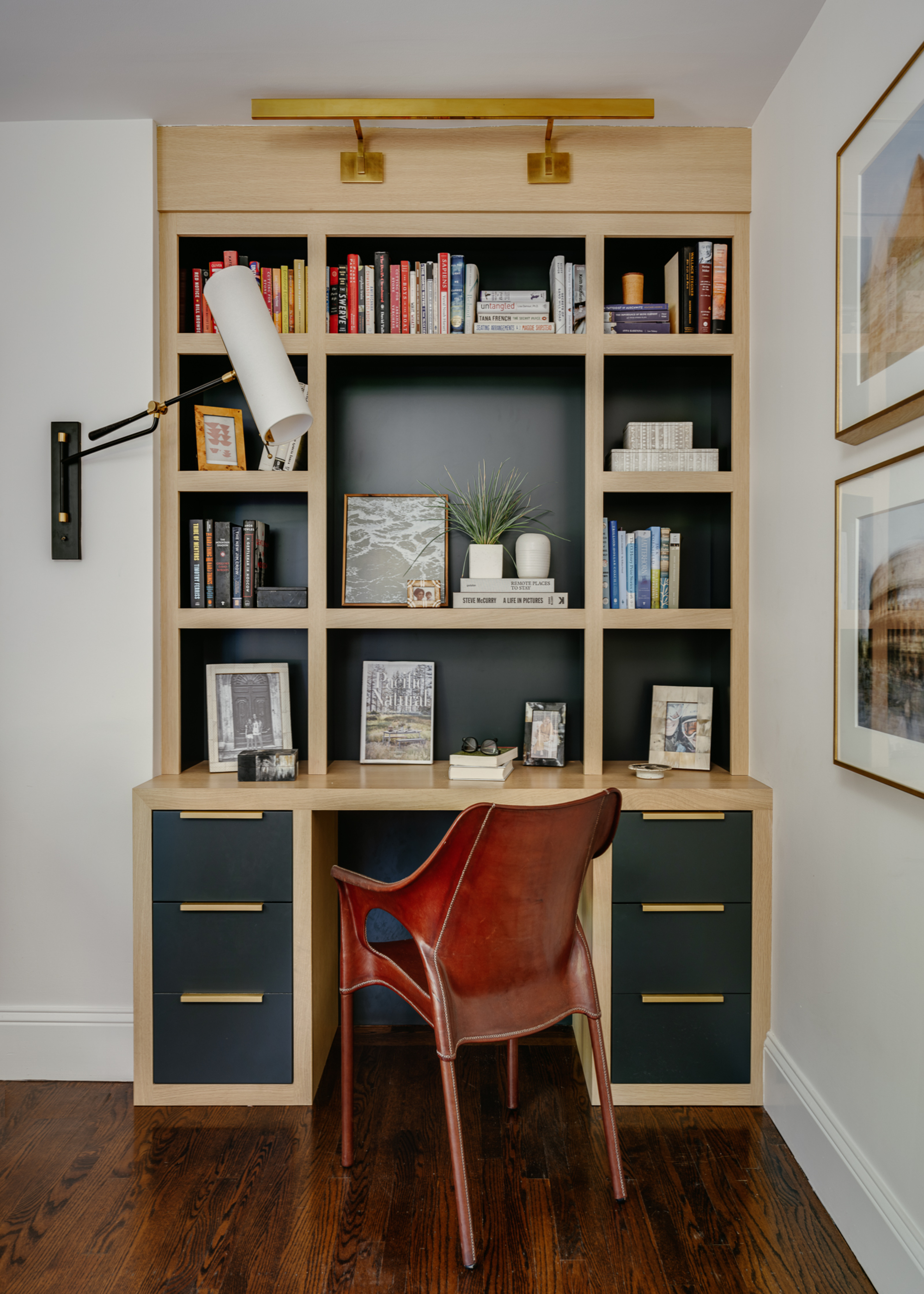 A desk space with built-in shelving and a leather chair