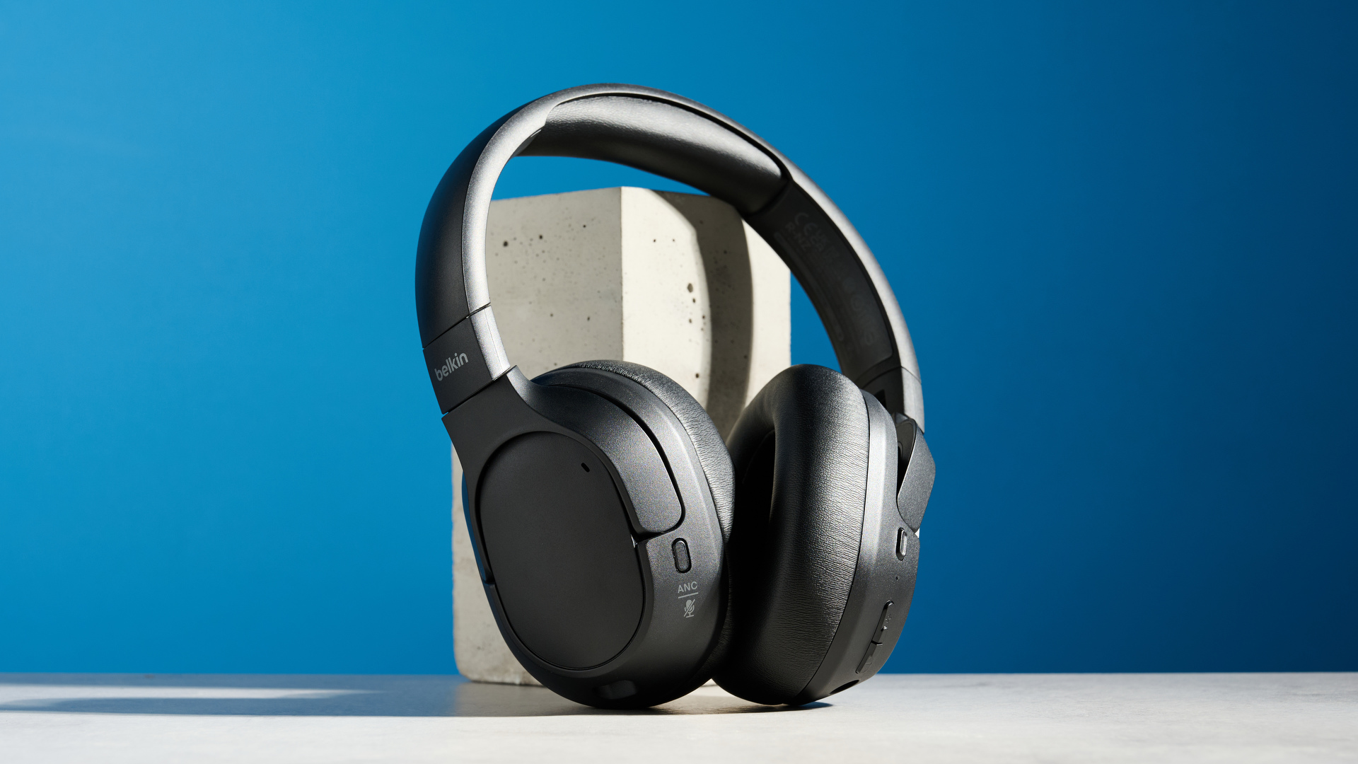 the belkin soundform isolate are a pair of budget headphones in black, with soft pillowy cups, control buttons on each cup, and ANC