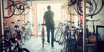 Bike shop owner rolls a bike out the door