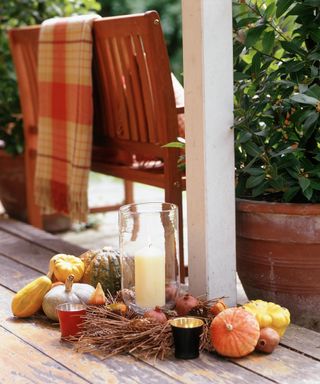 Fall porch with pumpkins grouped around a candle