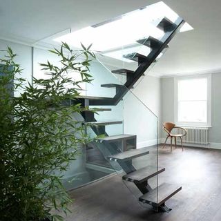 living room with stairs plants and white wall of house