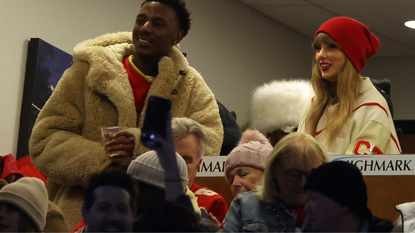 Jerrod Carmichael and singer-songwriter Taylor Swift watch the second quarter in the AFC Divisional Playoff game between the Kansas City Chiefs and the Buffalo Bills at Highmark Stadium