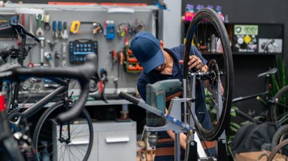 Mechanic fixes a wheel in a stand