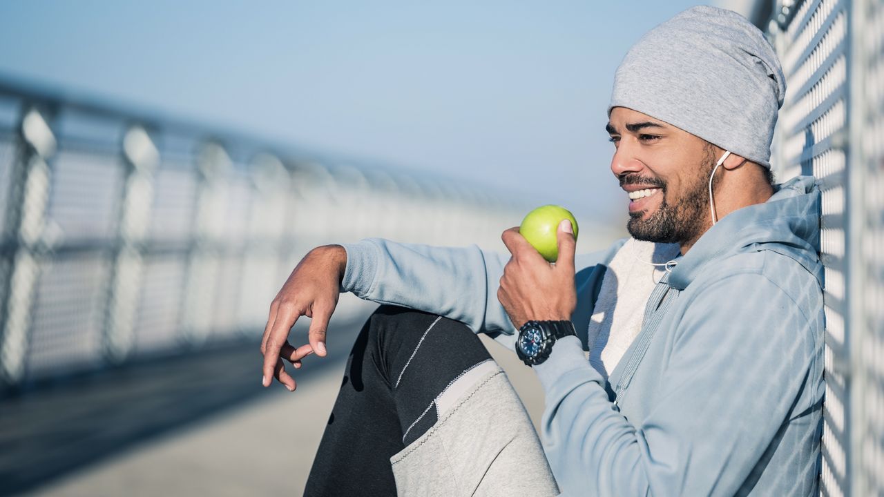 Man eating an apple outdoors