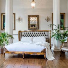 bedroom with wooden floor and grey bed