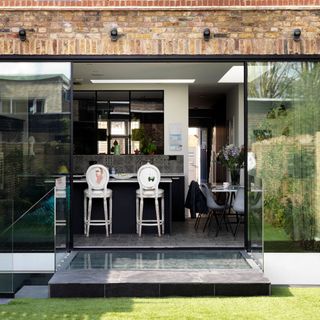 garden room with brick wall white and grey chairs