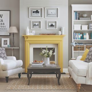 Grey living room with yellow accents, central fireplace with yellow mantleframe