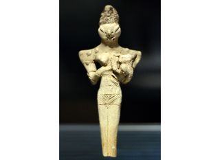 a figurine of a woman with the head of a lizard