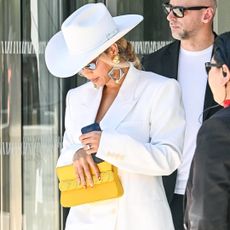 Beyoncé approves the turmeric yellow trend with a yellow handbag and a white suit set