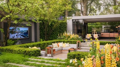Outdoor tv in a large backyard with outbuilding