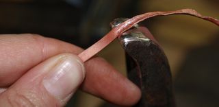 A copper strip bending to the forces of pressure