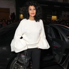 Tracee Ellis Ross with curled hair. She is wearing a white sweater and red lipstick.