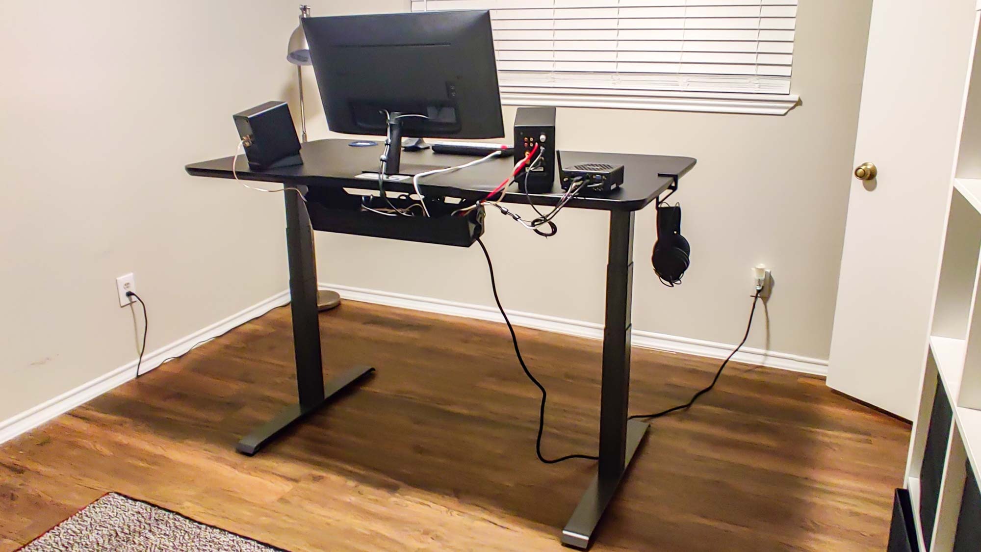 A Vari Electric Standing desk with a cable management tray