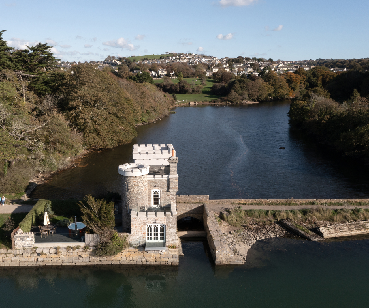 view of castle style home on a lake from above