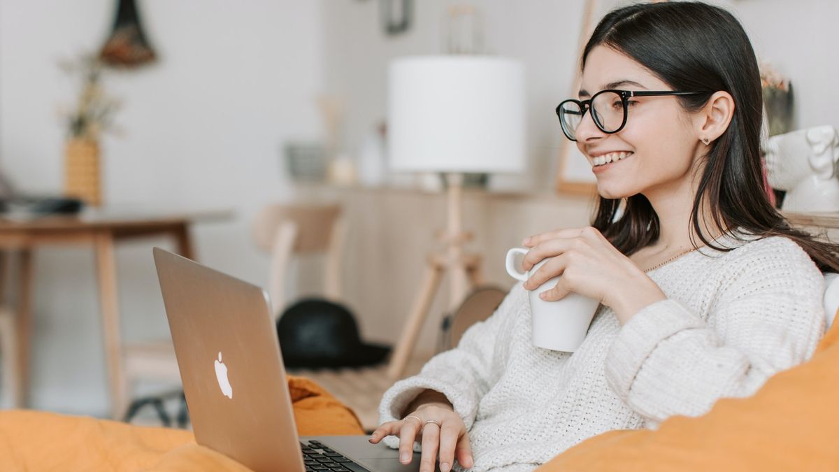 Download After Effects: Smiling woman using laptop and holding cup