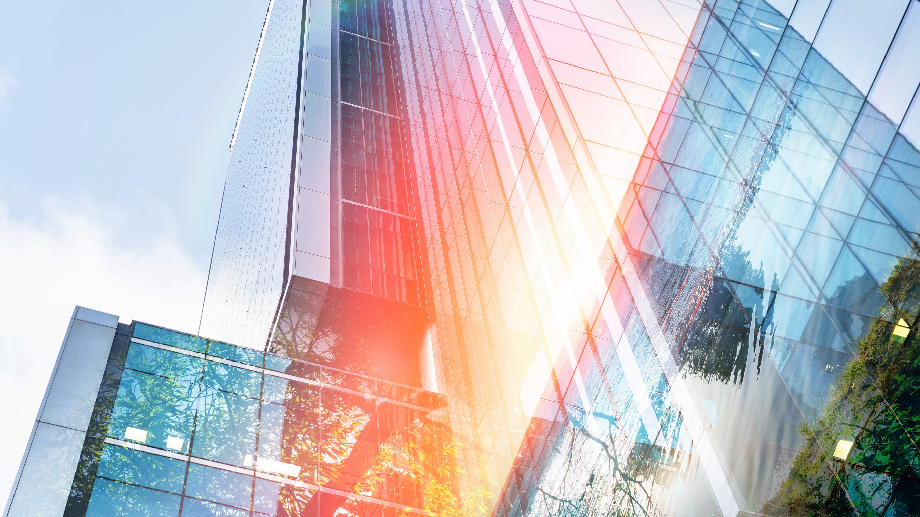 A view looking up at skyscrapers that makes them appear sunrise bright. 